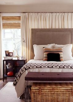 a bedroom with a large bed and wicker baskets on the nightstands next to it