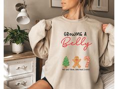 Surprise everyone this holiday season with our funny and cozy Christmas pregnancy sweatshirt reveal gift! This soft pregnancy reveal sweater is perfect for sharing the big news in a fun way. With a clever design, it's a playful pregnant announcement crewneck that will get smiles all around. Ideal for chilly days, this funny maternity fall shirt lets you show off your bump in style. Whether you're expecting or shopping for a mom-to-be, this preggers sweatshirt is the perfect festive addition to your wardrobe!   *Fast shipping in 2-5 Business Days! *Comfy unisex sweatshirts are soft and durable. *Measuring tip: Take your favorite sweatshirt or tee, lay it on a flat surface and measure the width (armpit to armpit) and length (top to bottom), then compare with our size chart. *Classic fit, dur Pregnancy Christmas Outfit, Pregnancy Sweatshirt, Pregnant Announcement, Funny Maternity, Christmas Pregnancy, Fall Maternity, Pregnancy Announcement Shirt, Pregnancy Humor, Pregnancy Reveal