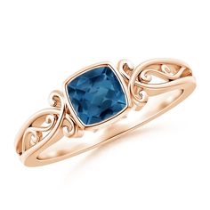 a gold ring with a blue topazte stone in the center and an intricate design on