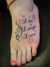 a woman's foot with the words live laugh love written on it and stars