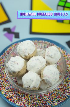 some white frosted donuts in a bowl on a plate with sprinkles