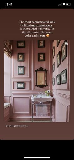 a bathroom with pink walls and pictures on the wall, along with a white sink