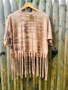 an old t - shirt with fringes hanging on a wooden fence