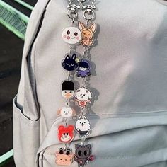 a backpack with several key chains hanging from it's front pocket and attached to the back