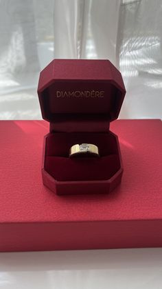 a diamond ring in a red box on a table