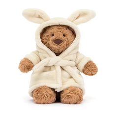 a brown teddy bear wearing a white robe and bunny ears on it's head