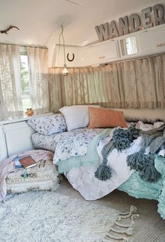 an instagram photo of a bed with pillows and blankets on it, in front of a window