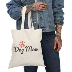 a woman holding a dog mom tote bag