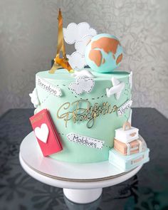 a birthday cake decorated with the eiffel tower and other things on top of it