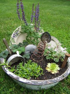 a potted planter filled with plants and gardening implements on top of green grass