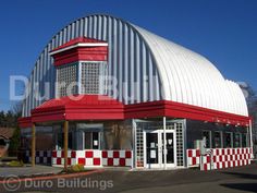 a large red and white building sitting on the side of a road