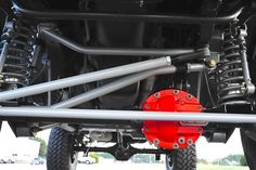 the rear end of a vehicle with two large red springs on it's front suspensions