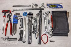 tools are laid out on a table to be used for repair and maintenance, including wrenches, pliers, screwdrives, etc