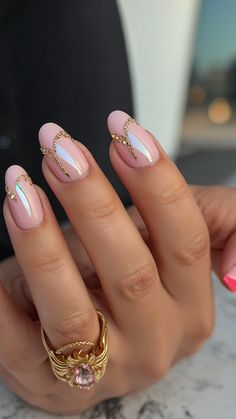 a woman's hand with pink and white manicures on her nails, gold ring