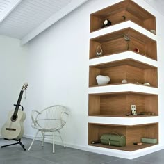 a guitar is sitting in front of a book shelf