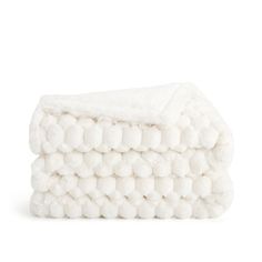 two white towels stacked on top of each other with pom - poms in the middle