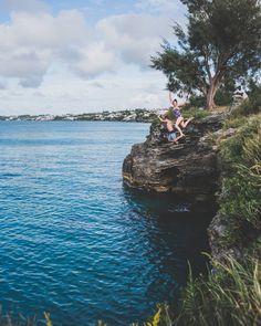 a person jumping into the water from a cliff