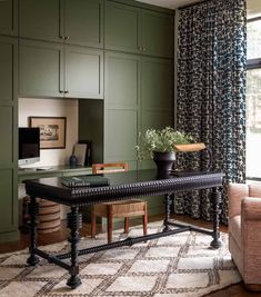 a living room filled with furniture and green cupboards next to a window covered in curtains