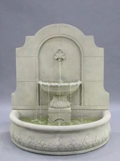 a white fountain with water flowing from it's sides