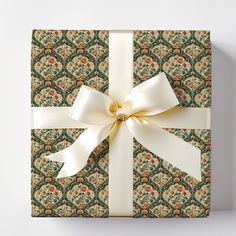 a gift box with a white ribbon tied around the top and an ornate pattern on it