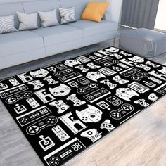 a black and white rug with video game controllers on it in front of a couch