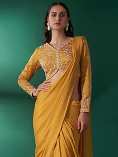 This is a two-piece mustard yellow pre draped saree set from the Suruchi Parakh collection. The mustard yellow saree in georgette crepe is paired with a hand-embroidered blouse. The satin base blouse has padding and a back hook opening. There is beautiful embroidery work all over the blouse. Yellow Embroidered Saree With Traditional Drape, Marrige Dress, Mustard Yellow Saree Contrast Blouse, Yellow Silk Pre-draped Saree With Unstitched Blouse, Mustard Colour Saree, Mustard Yellow Saree, Mustard Saree, Pre Draped Saree, Satin Kurta