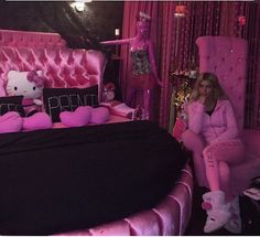 a woman sitting in a pink chair next to a hello kitty bed