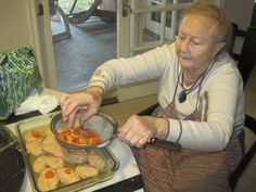 an older woman is cooking some food on the stove