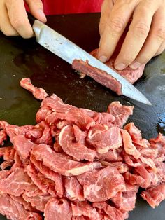 a person cutting up meat with a knife