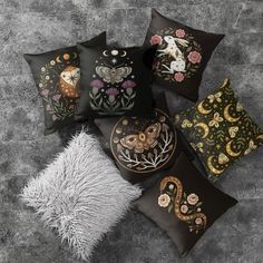 four decorative pillows with embroidered animals and flowers on them, all in different sizes and colors