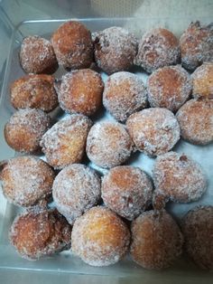 powdered sugar covered donuts in a plastic container