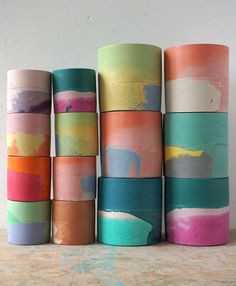 there are many rolls of colored paper on the table next to each other and one is painted with different colors