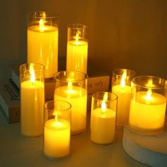 many lit candles sitting on a table next to a box with a candle in it