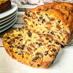 a loaf of bread with raisins and chocolate chips on it next to plates