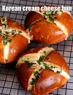 four baked breads with cheese and herbs on a cooling rack in front of the words korean cream cheese bun