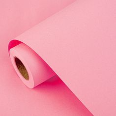 a roll of pink paper sitting on top of a table