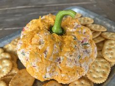 a cheese ball sitting on top of crackers with a green pepper sticking out of it