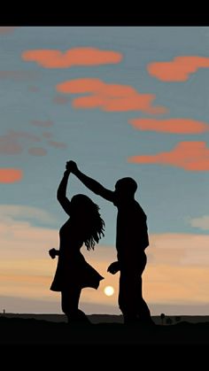 two people holding hands in front of a sunset