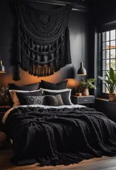 a bedroom with black walls and wooden flooring is decorated in shades of dark grey