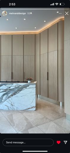 an image of a marble counter top in a room with wooden cupboards and lights