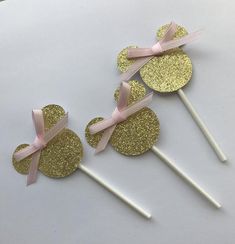 gold glitter cake toppers with pink bows on them