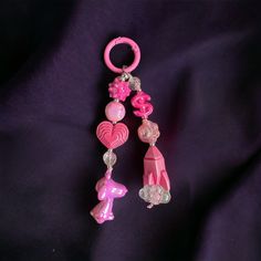 a pink key chain with charms attached to it