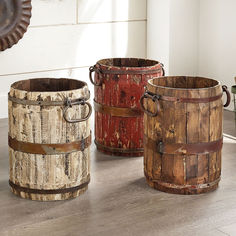 three wooden buckets sitting next to each other on top of a wood floor in front of a white wall