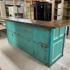 a kitchen island made out of an old door and some cupboards in the background