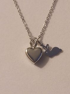 Silver Small Heart with Rabbit/Bunny Charm Cremation Urn Necklace comes with everything needed to help you get the ashes into the urn at no additional cost.  ** This necklace is also available in gold. Heart Urn, rabbit/bunny charm and chain are all stainless steel.  Heart urn measures approximately ½ inch by ½ inch. To personalize your necklace please take a look in our "ADD On" section.  We have initials, Memorial charms, birthstones and much more in which will help to make your piece even MOR Heart-shaped Keepsake Charm Necklaces, Hypoallergenic Necklace For Valentine's Day Keepsake, Accessory Inspo, Ashes Necklace, Cremation Necklaces, Urn Necklace, Urn Necklaces, Cremation Jewelry, Cremation Urns