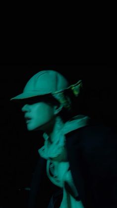 a person wearing a hat and scarf in the dark