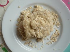 a white plate topped with oatmeal covered food on top of a table