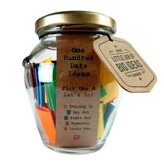 a jar filled with lots of different colored pencils next to a tag that says, one hundred date ideas