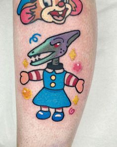 a person with a tattoo on their leg that has an image of a cartoon character