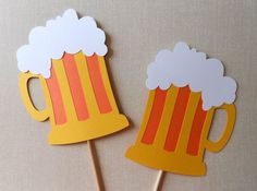 two paper beer mugs on top of toothpicks